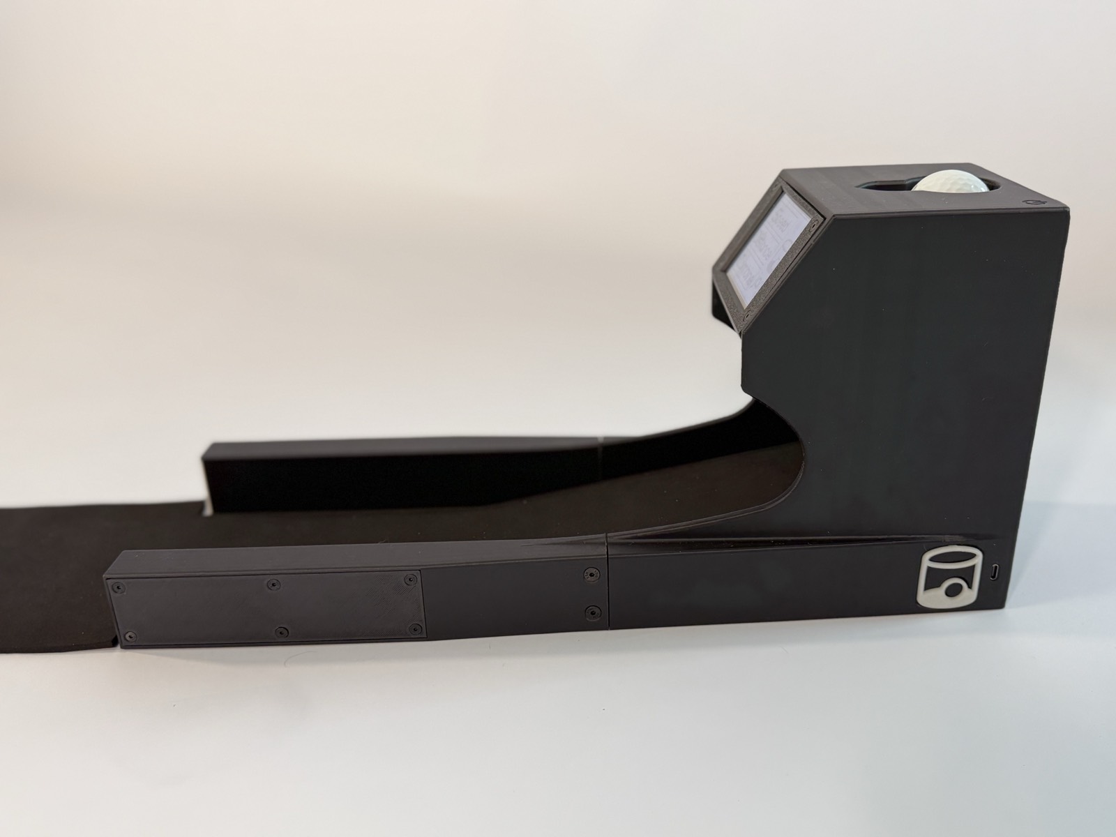 The Speed Machine putting trainer, full side view with a ball loaded and the speed readout screen visible