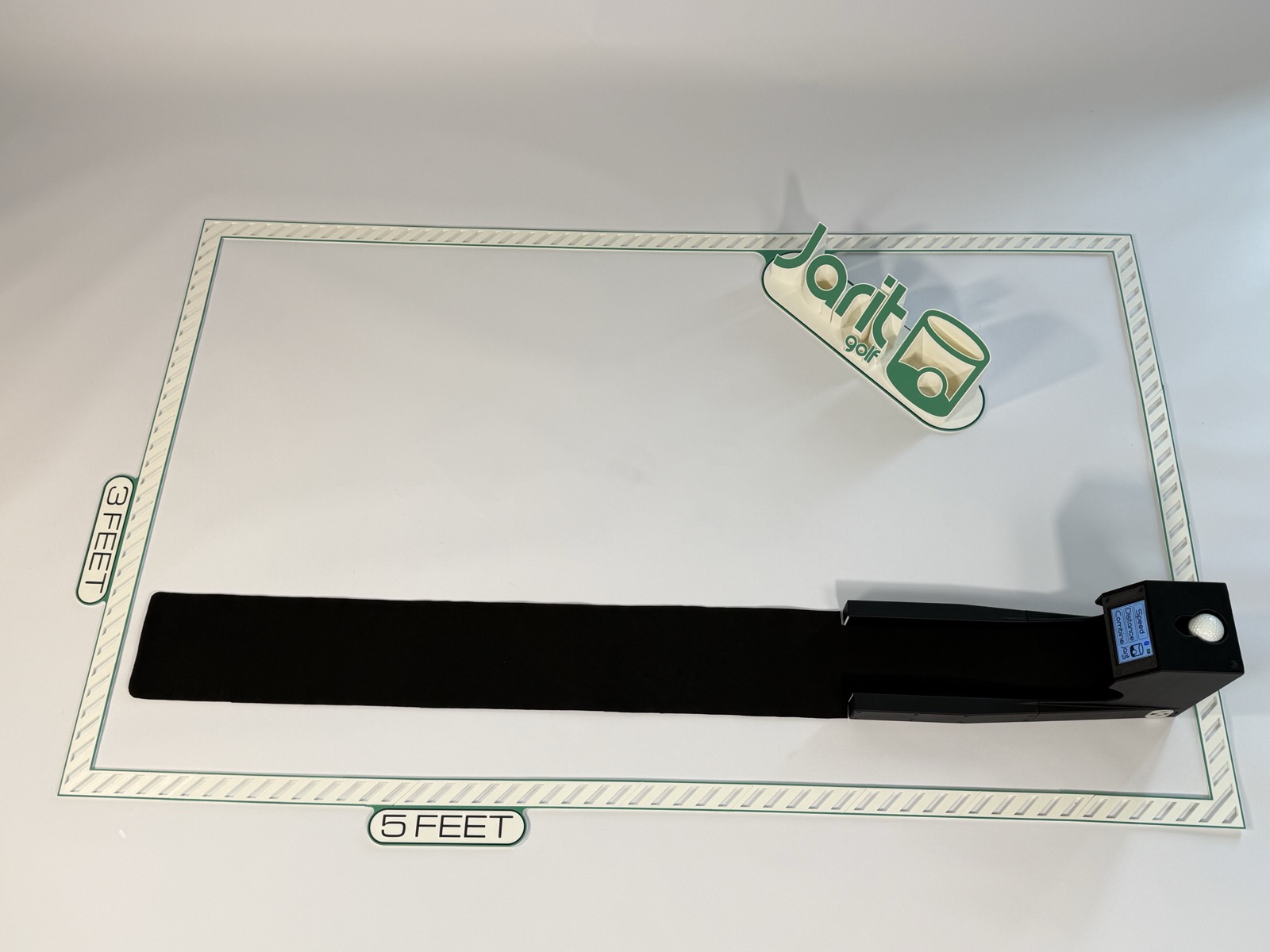 The Speed Machine viewed from directly above on its practice mat, showing the full return track and the Jarit Golf mark